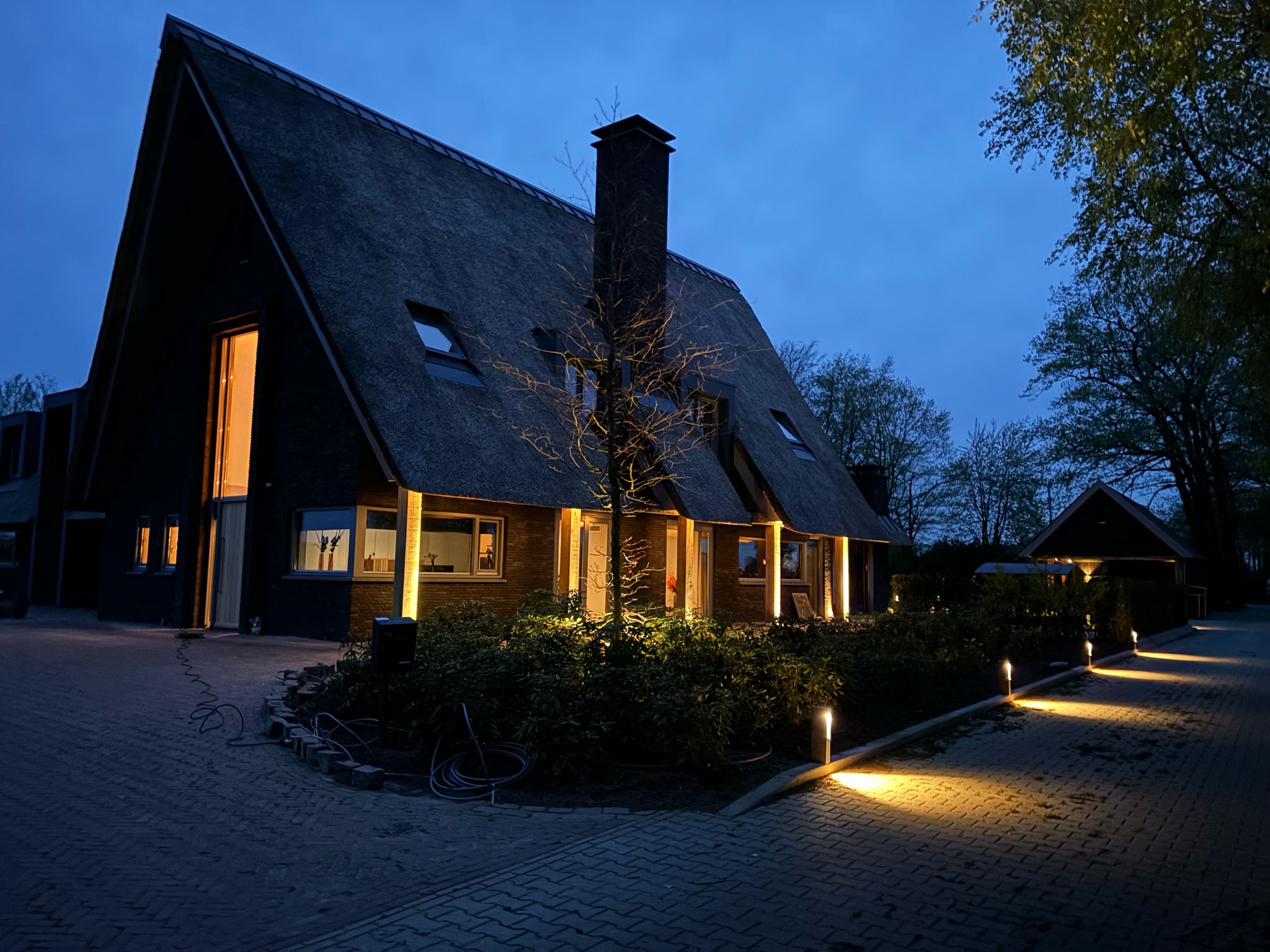 Moderne woning met sfeervolle buitenverlichting in de avond