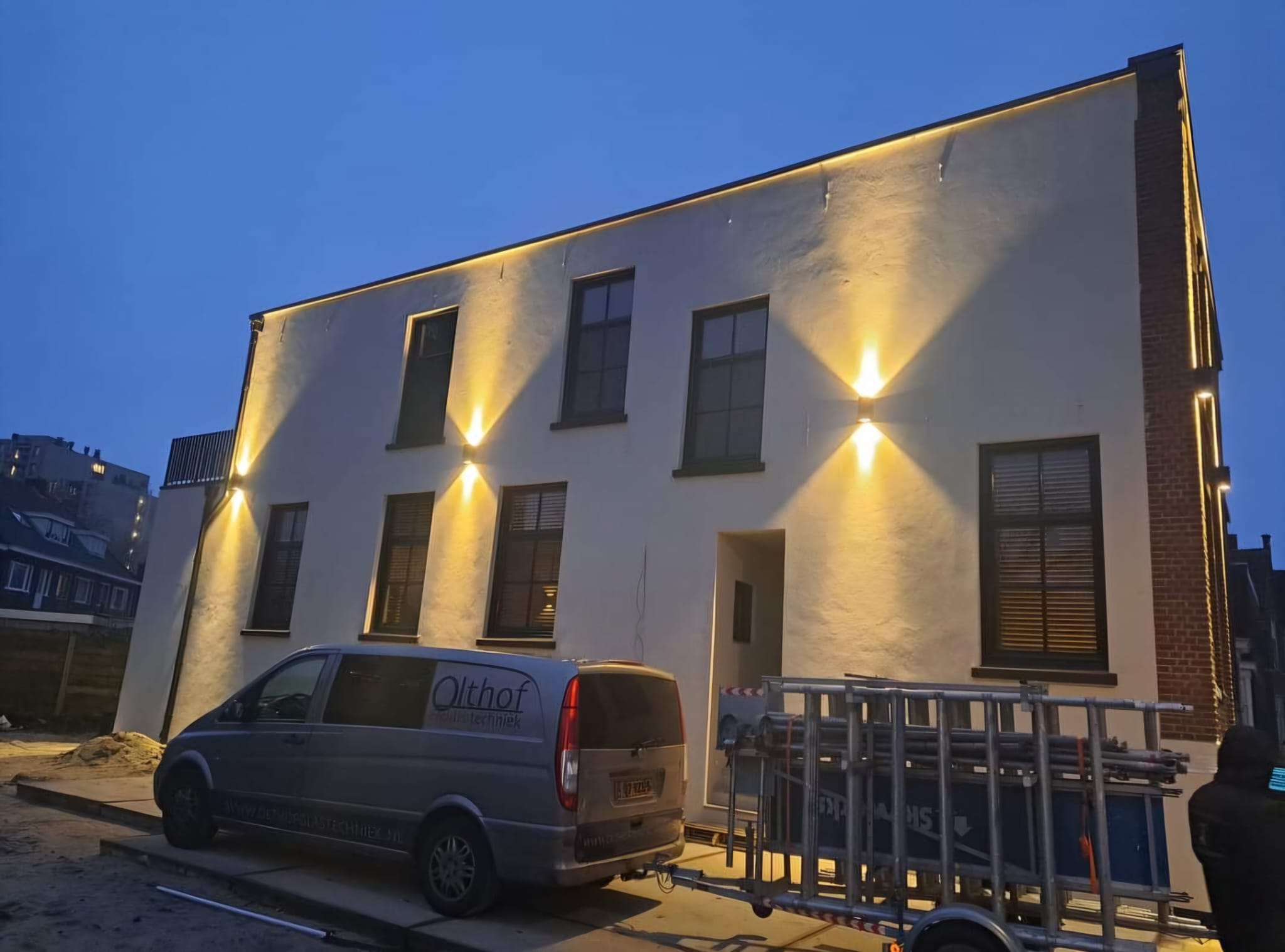 Verlichte gevel van een modern bedrijfspand in de avond