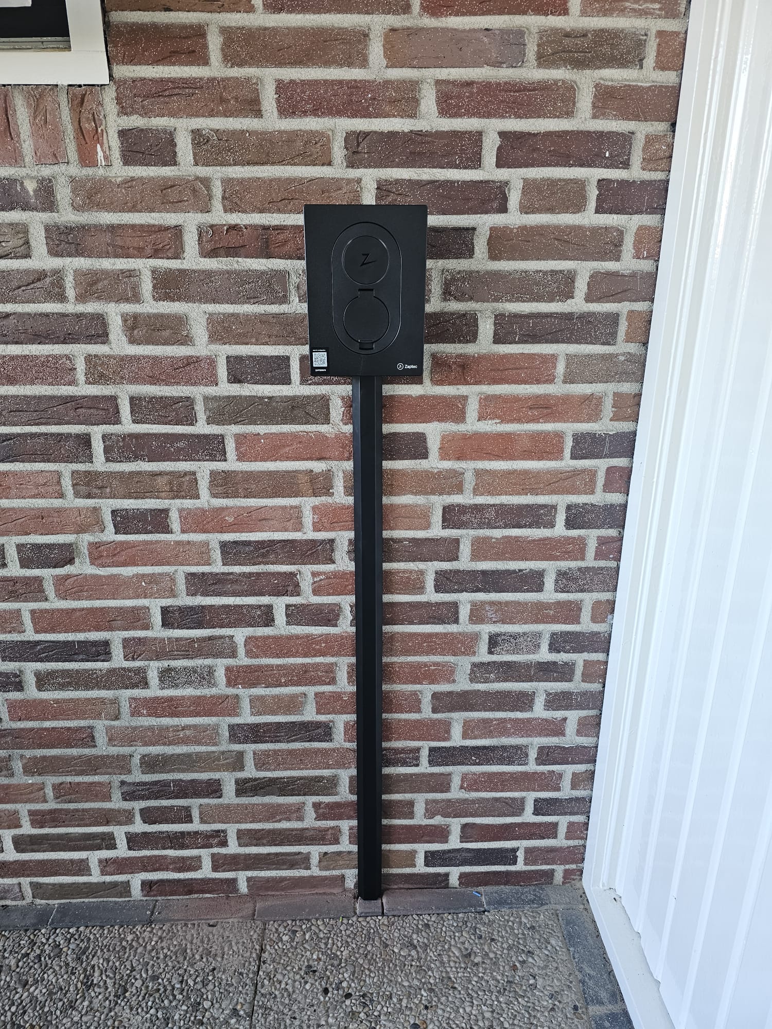 Elektrische laadvoorziening aan een bakstenen gevel